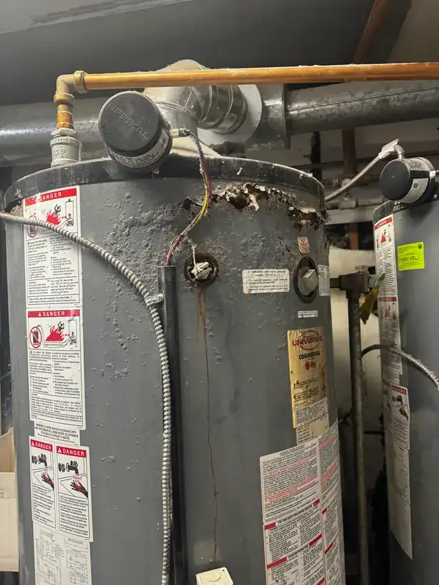 Old corroded gas water heater photographed before it was replaced