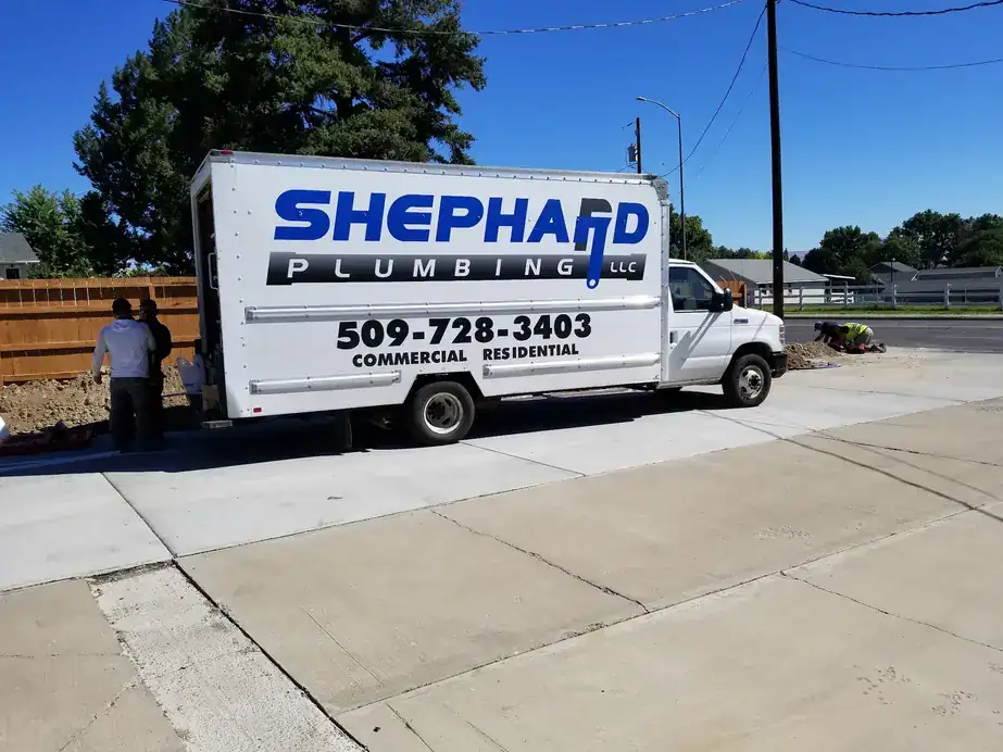 Shephard box truck parked on a new sidewalk at a jobsite