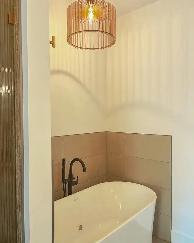 Finished bathroom remodel with a freestanding tub and a black floor-mount filler