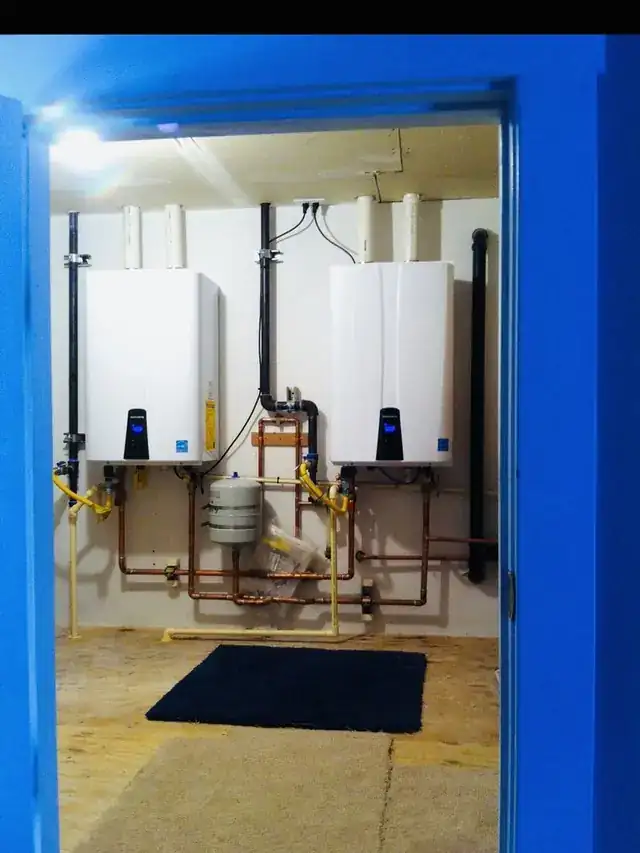 Two Navien tankless water heaters installed in a commercial mechanical room