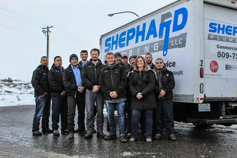 An earlier Shephard Plumbing crew photo taken in the snow with the company truck behind them