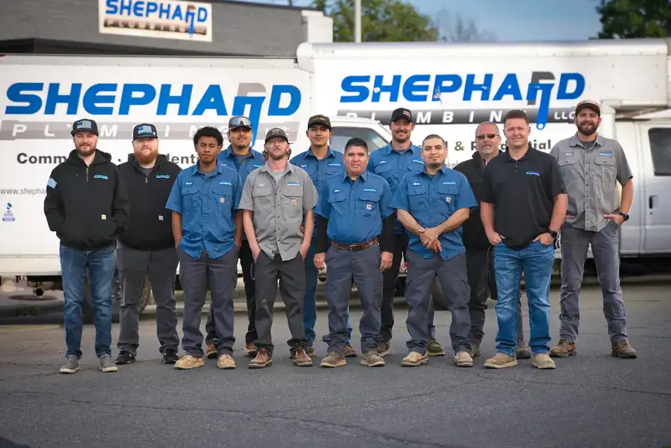 The 2025 Shephard crew of twelve standing in front of two lettered box trucks