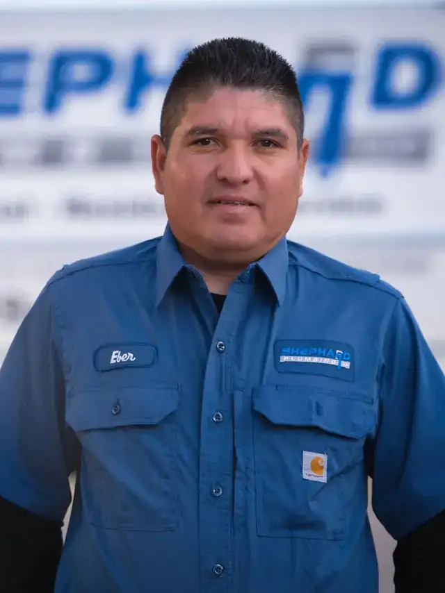 Ever Espinosa, Plumber at Shephard Plumbing, in a name-tagged work shirt in front of the box truck